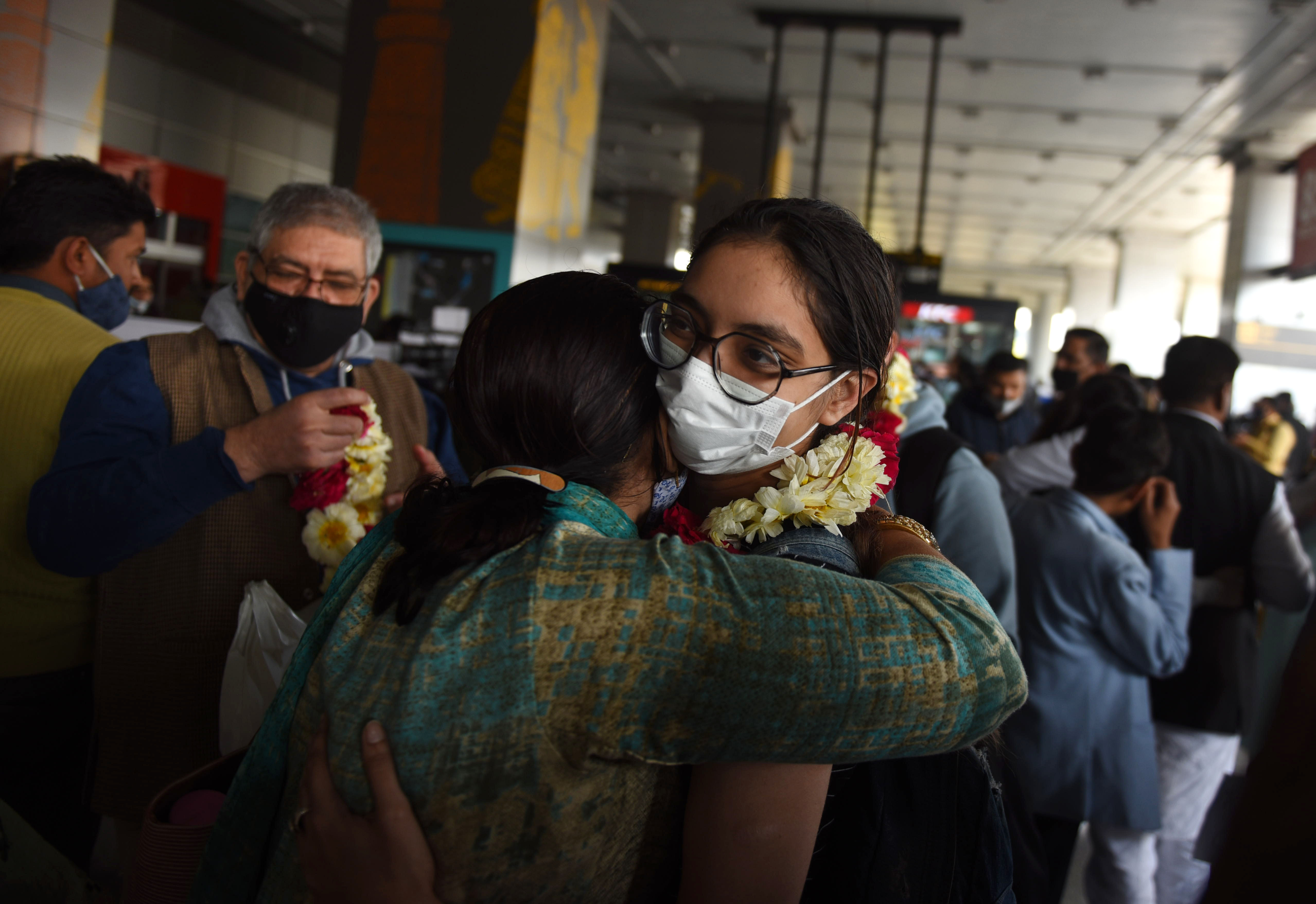 Female student hugging another female in a travel area after successfully returning to India from Ukraine